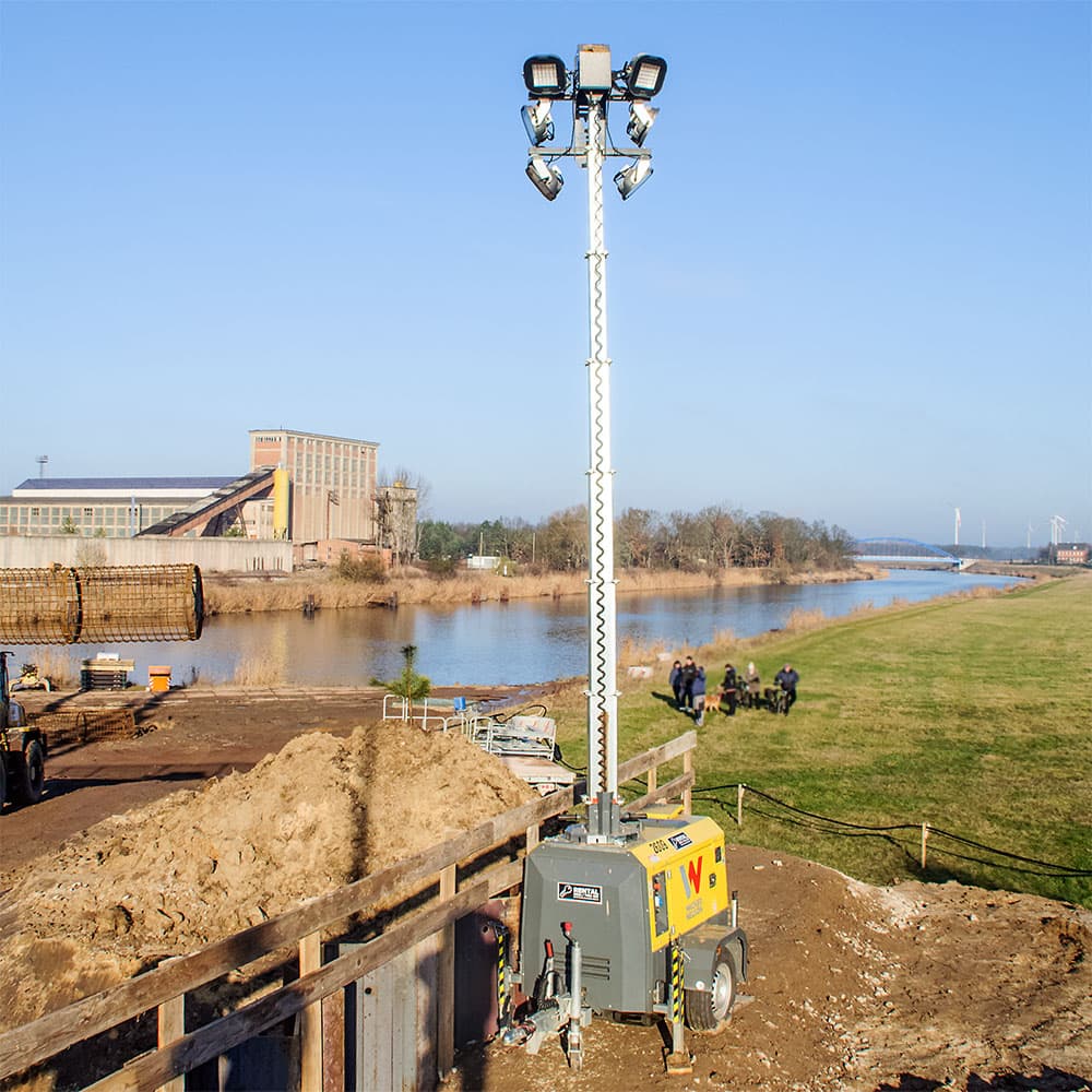 Mobile diesel lighting tower with mast raised on a construction site