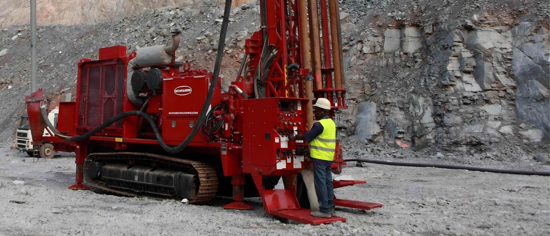 An RC drilling rig uses compressed air and dual-wall drill rods to bring rock-chip samples to the surface.