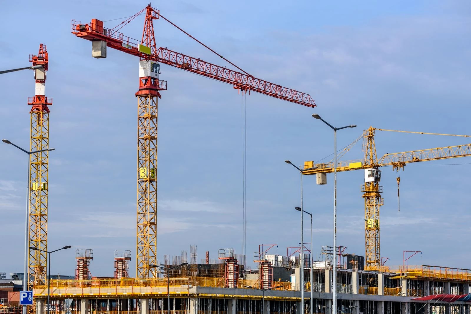 A tower crane lifts construction loads along its jib, with lifting capacity depending on the load radius.